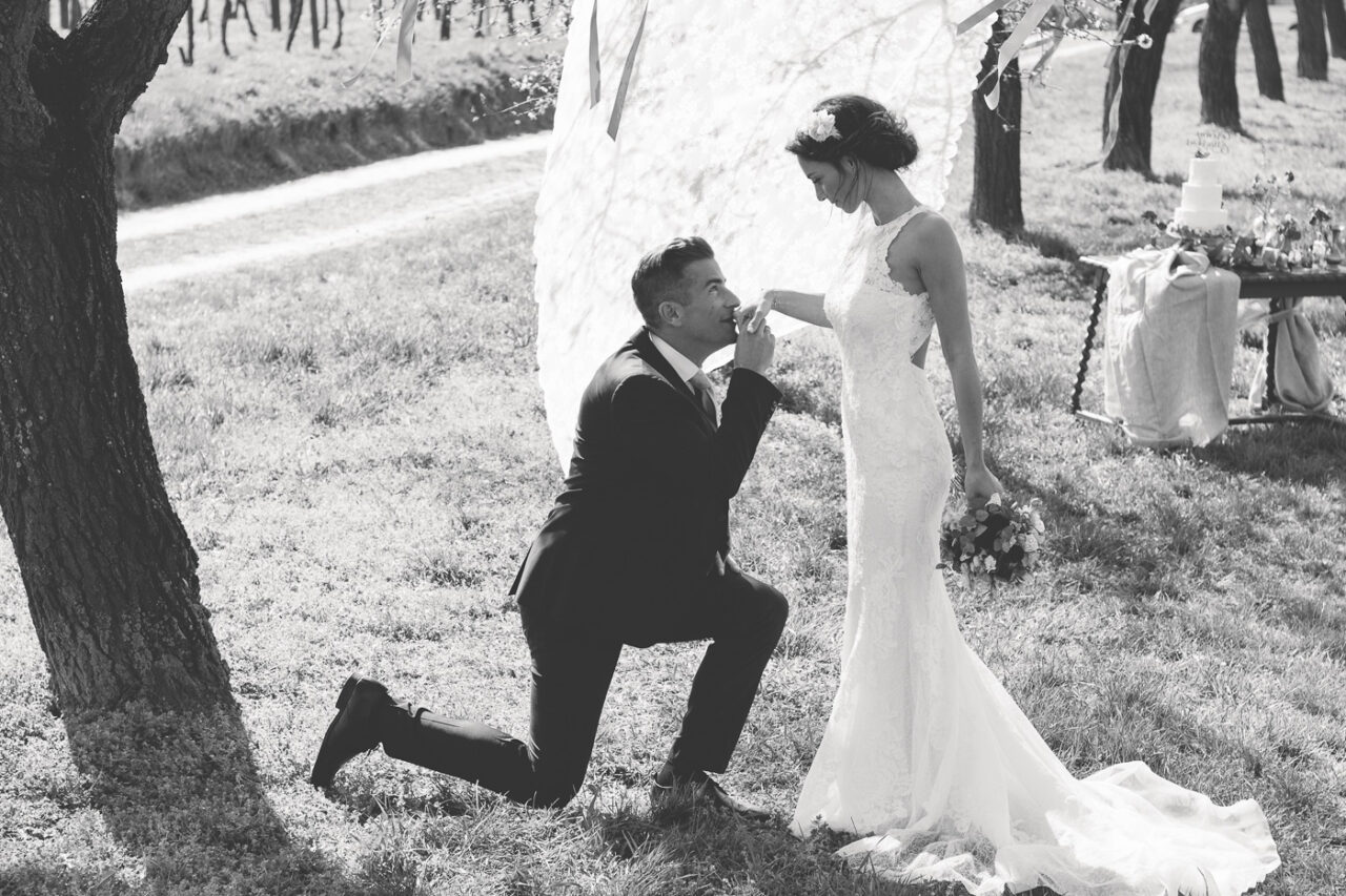 Braeutigam kuesst auf der Hochzeit die Hand der Braut und wird fotografiert von Fotograf Markus Winkelbauer