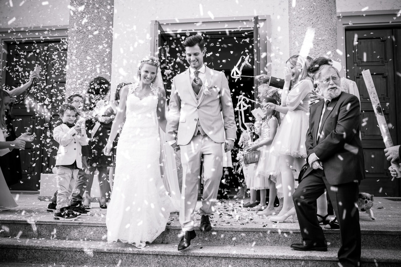 Brautpaar nach der Trauung mit Reis beworfen und wird von Fotograf Markus Winkelbauer fotografiert