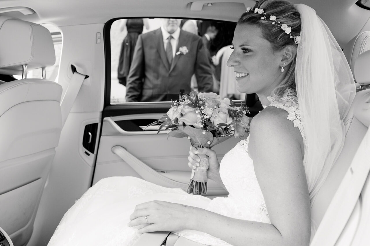 Die Braut kurz bevor sie in die Kirche geht und dabei in schwarz weiss von Fotograf Markus Winkelbauer fotografiert wird