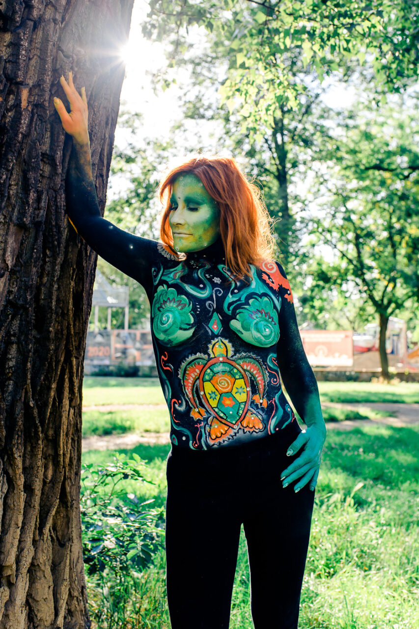 Frau mit Bodypainting auf Oberkoerper und im Gesicht fotografiert im Park von Fotograf Markus Winkelbauer