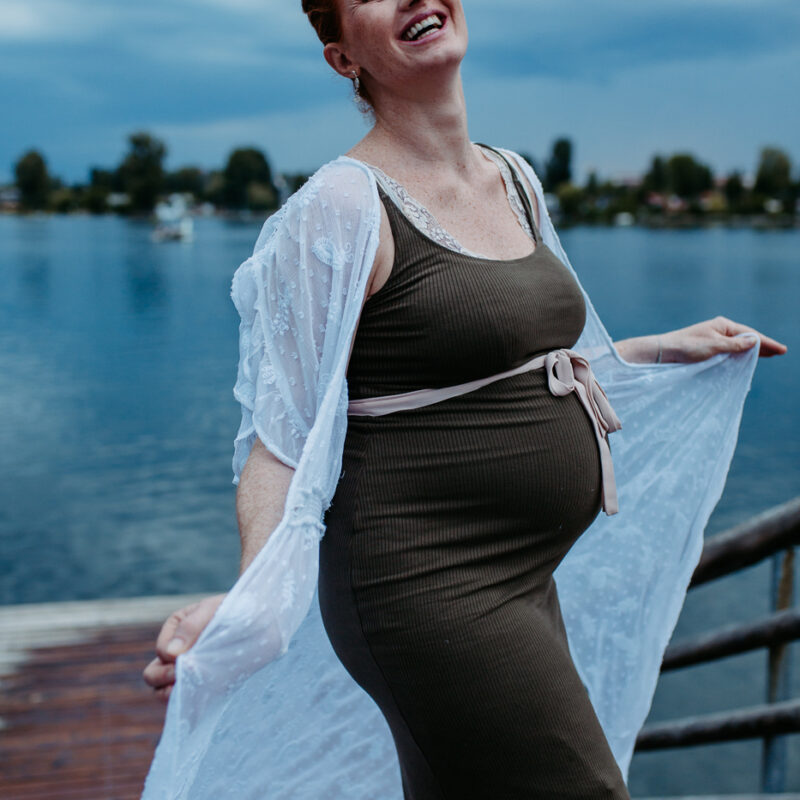 Glueckliche lachende Schwangere beim Fotoshooting an der alten Donau mit Fotograf Markus Winkelbauer