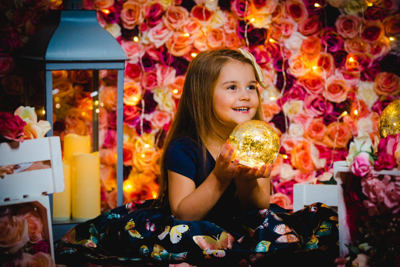 Glueckliches Kind mit Lichterkugel fotografiert beim Weihnachtsfotoshooting im Fotostudio von Fotograf Markus Winkelbauer in Wien