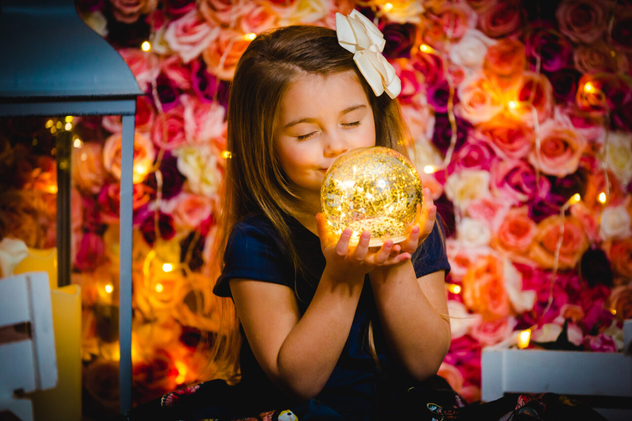 Zufriedenes Maedchen beim weihnachtlichen Fotoshooting mit Blumen mit Fotograf Markus Winkelbauer